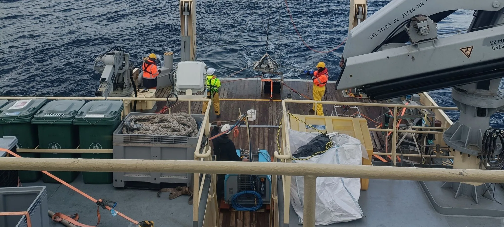 Picture of survey team operating a winch on the back of a boat