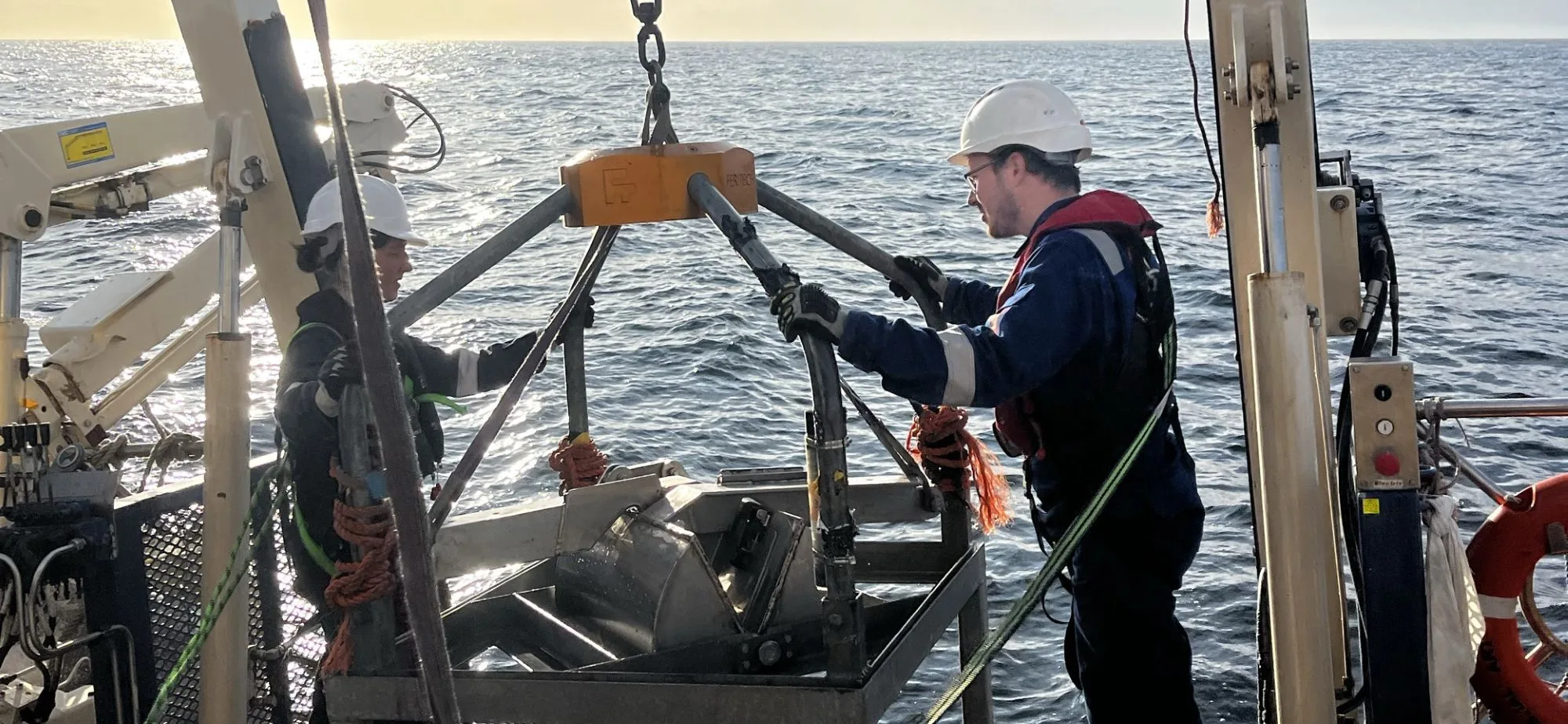 Picture of crew members preparing to launch a grab over the side of the boat