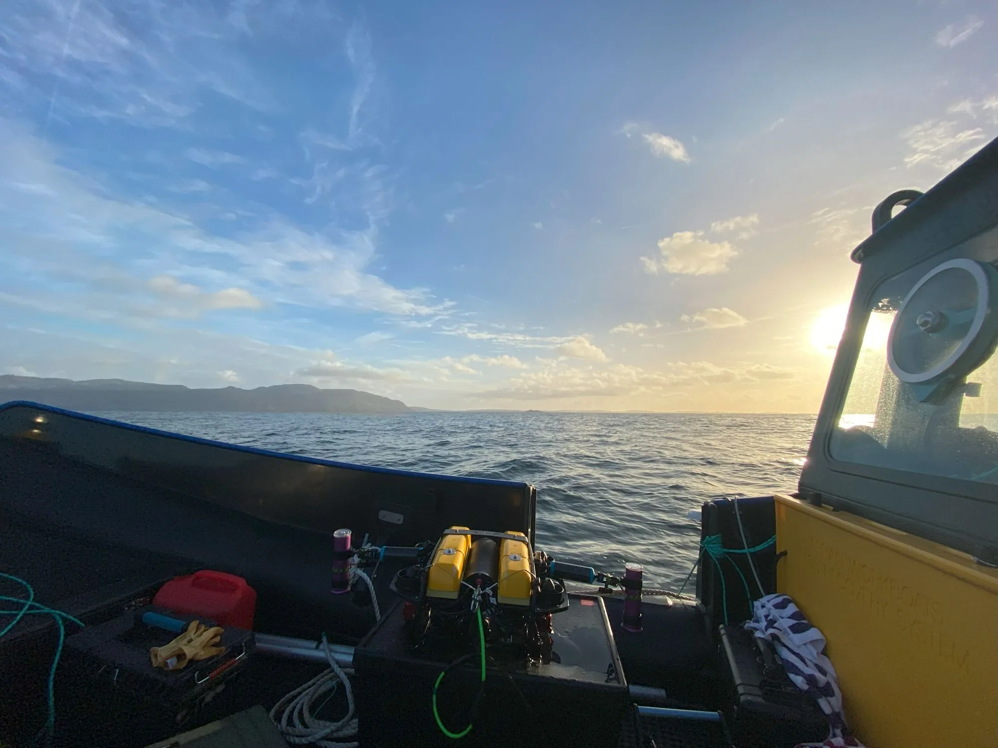 Picture of the side of a boat heading out to sea to conduct the survey