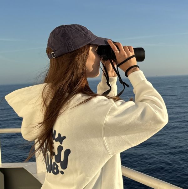Picture of a Marine Mammal Observer looking through binoculars
